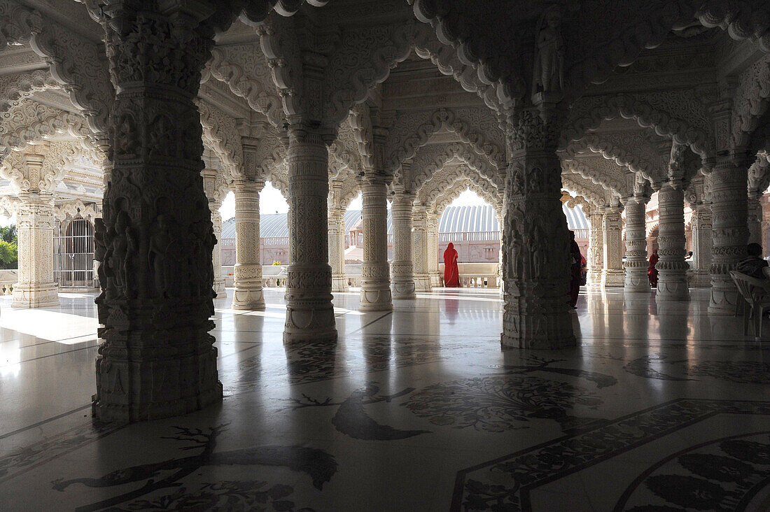 Woman in red sari in the marble pillared hall of Shri Swaminarayan temple, built after the 2001 earthquake, Bhuj, Gujarat, India, Asia