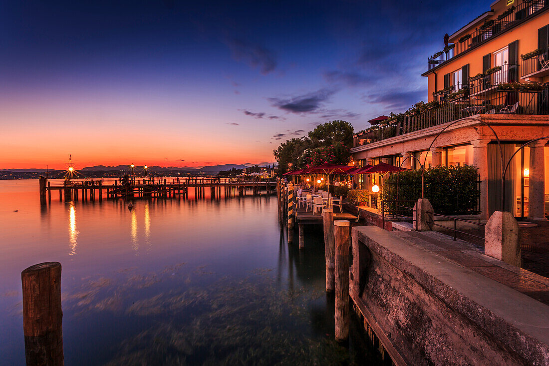 View of golden sunset and restaurant overlooking Lake Garda, Sirmione, Lake Garda, Lombardy, Italian Lakes, Italy, Europe