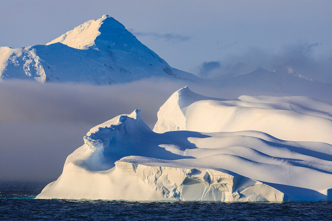 Huge non-tabular iceberg, mountains, evening light and mist, Bransfield Strait, South Shetland Islands, Antarctica, Polar Regions