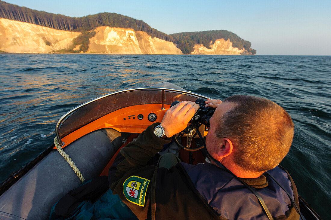 Ranger kontrolliert mit kleinem Schlauchboot die Kreidefelsen, Rügen, Ostseeküste, Mecklenburg-Vorpommern, Deutschland
