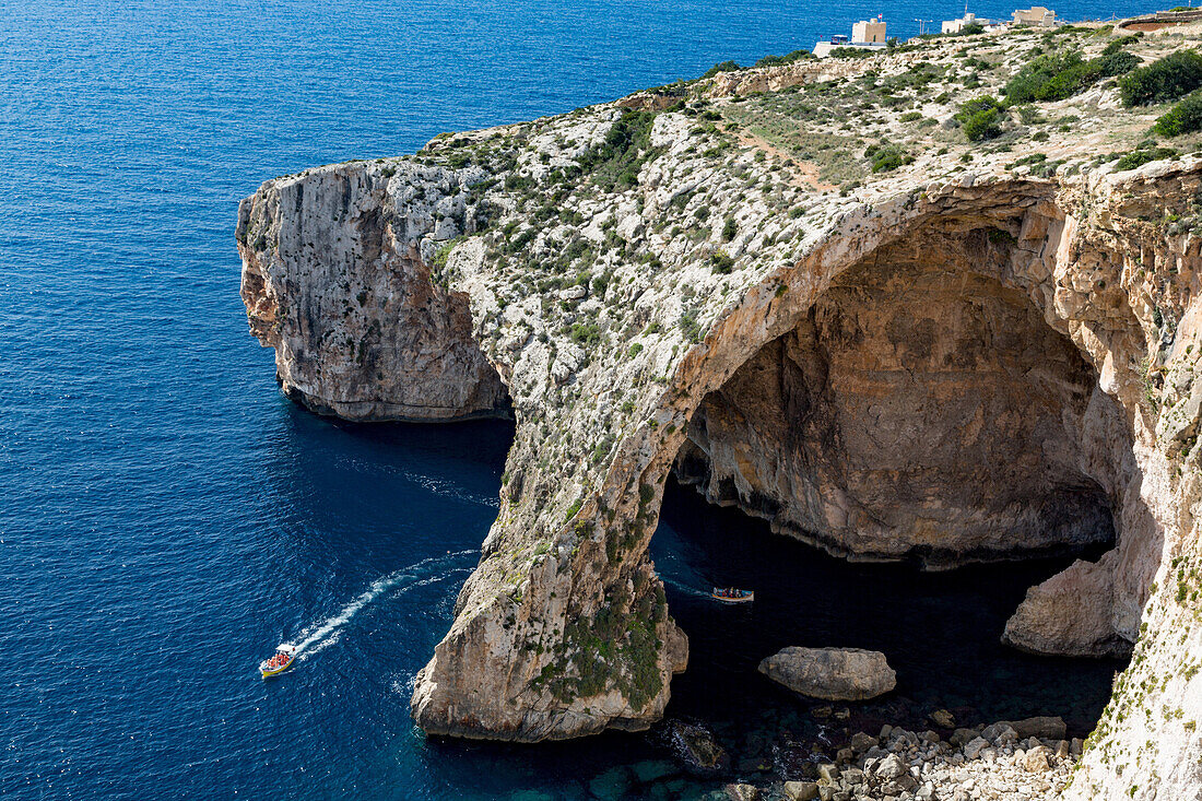 Boats of tourists visiting the dramatic natural arch at the Blue Grotto, Malta, Mediterranean, Europe