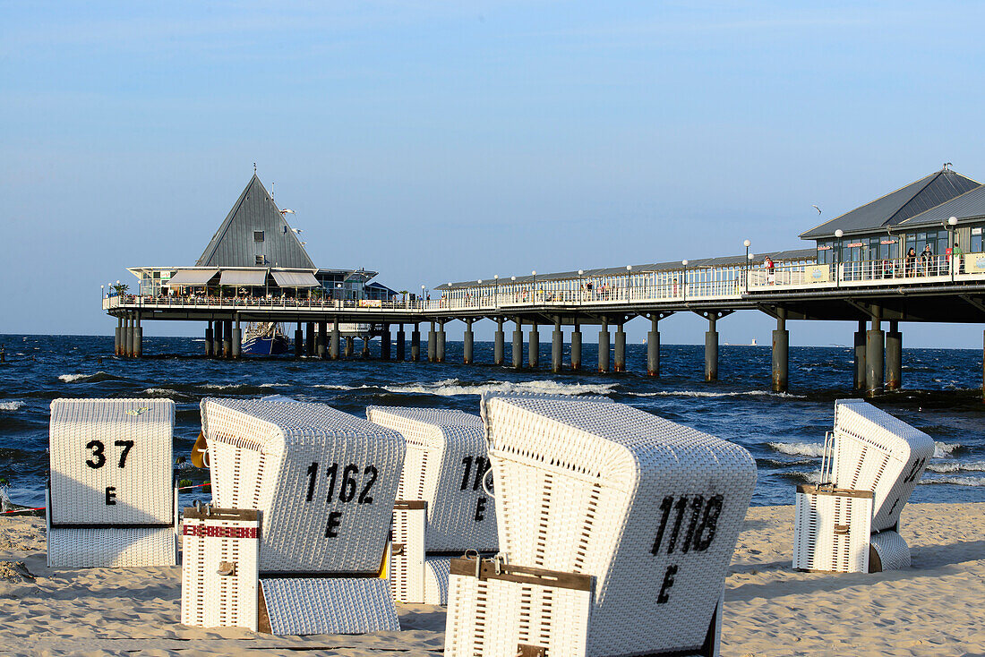 Beach chairs in front of the pier with shops and outdoor restaurant, Heringsdorf, Usedom, Ostseeküste, Mecklenburg-Western Pomerania, Germany