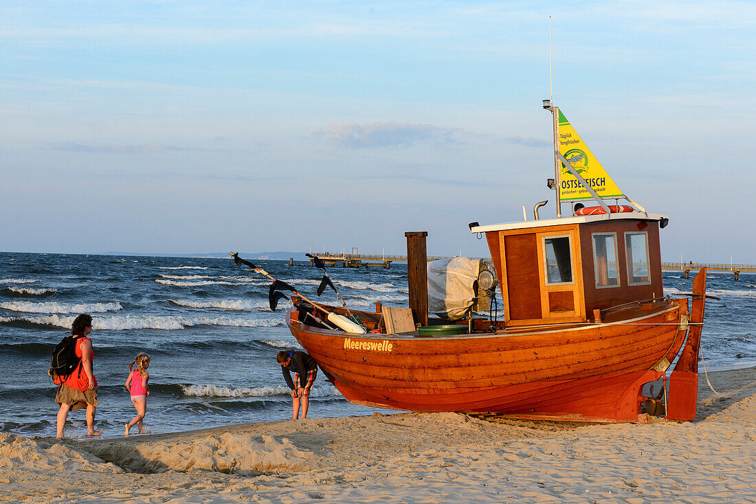 Mutter mit Kindern und kleines Fischerboot aus Holz  am Strand von  Ahlbeck, Usedom, Ostseeküste, Mecklenburg-Vorpommern, Deutschland