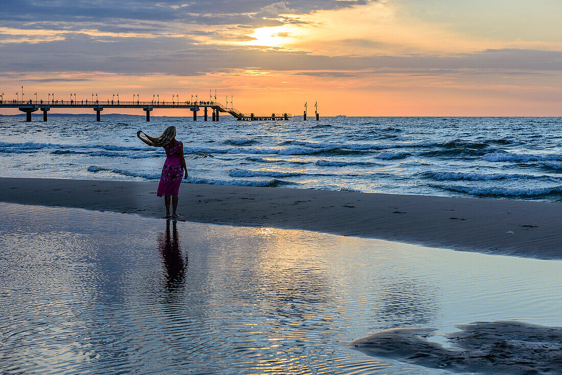 Beach with woman and sunset from Miedzyzdroje, Wollin island, Baltic Sea coast, Poland