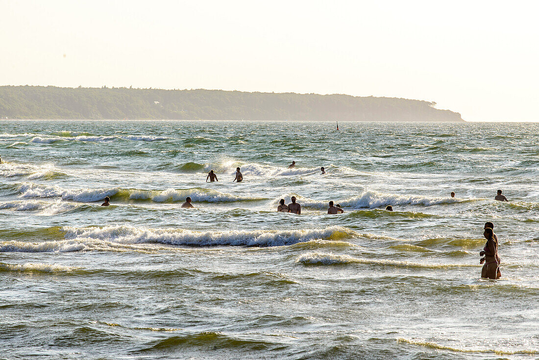 Badende in den Wellen am Strand, Warnemünde, Rostock, Ostseeküste, Mecklenburg-Vorpommern, Deutschland