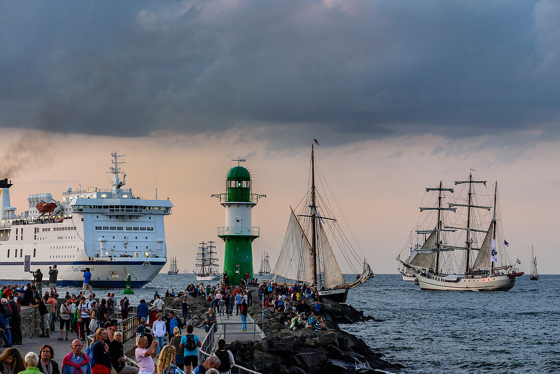 Segelschiffe und Fähre in Warnemünde mit Schaulustige und Leuchtturm zur Hansesail, Warnemünde, Rostock, Ostseeküste, Mecklenburg-Vorpommern, Deutschland