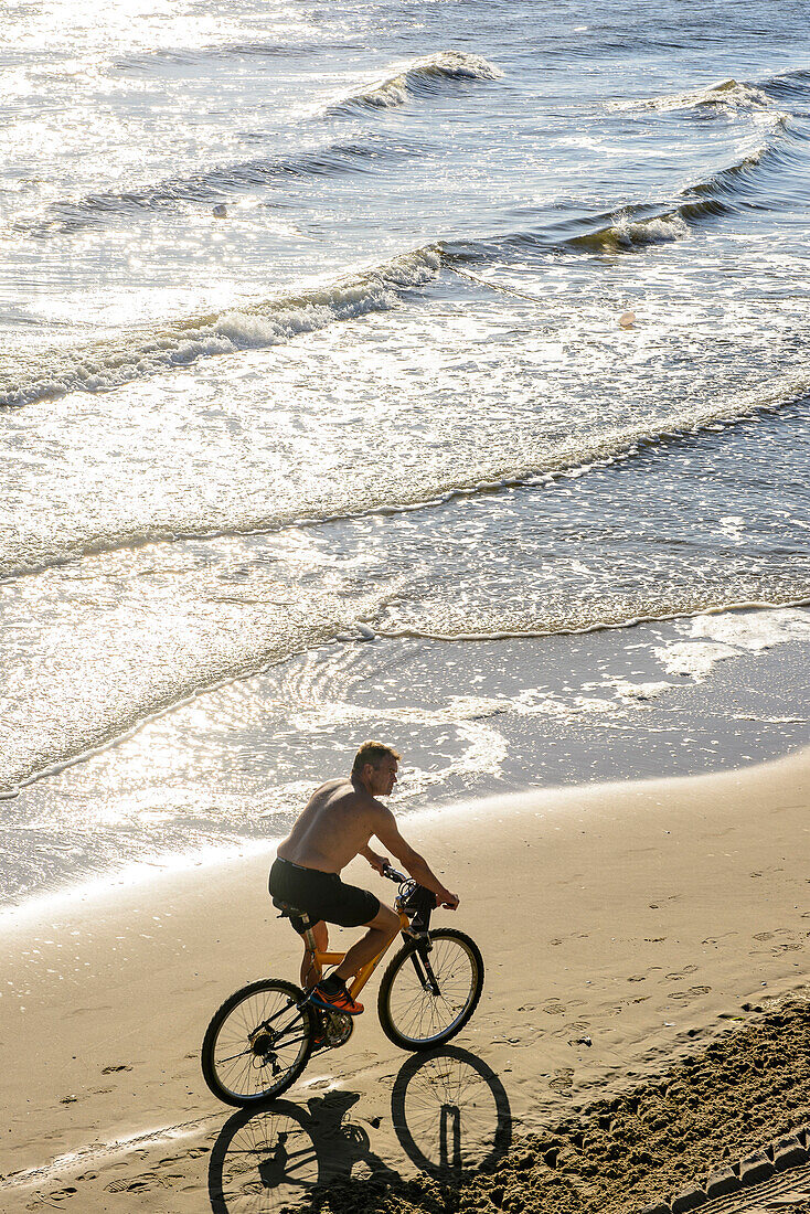Radfahrer mit freiem Oberkörper am Strand, Heringsdorf, Usedom, Ostseeküste, Mecklenburg-Vorpommern, Deutschland