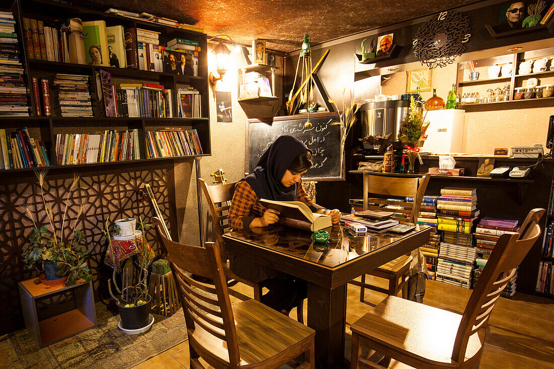 Reading woman in cafe, Esfahan, Iran, Asia