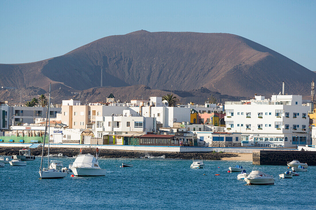 The waterfront of old town Corralejo on the island of Fuerteventura with a volcano in the distance, Fuerteventura, Canary Islands, Spain, Atlantic, Europe