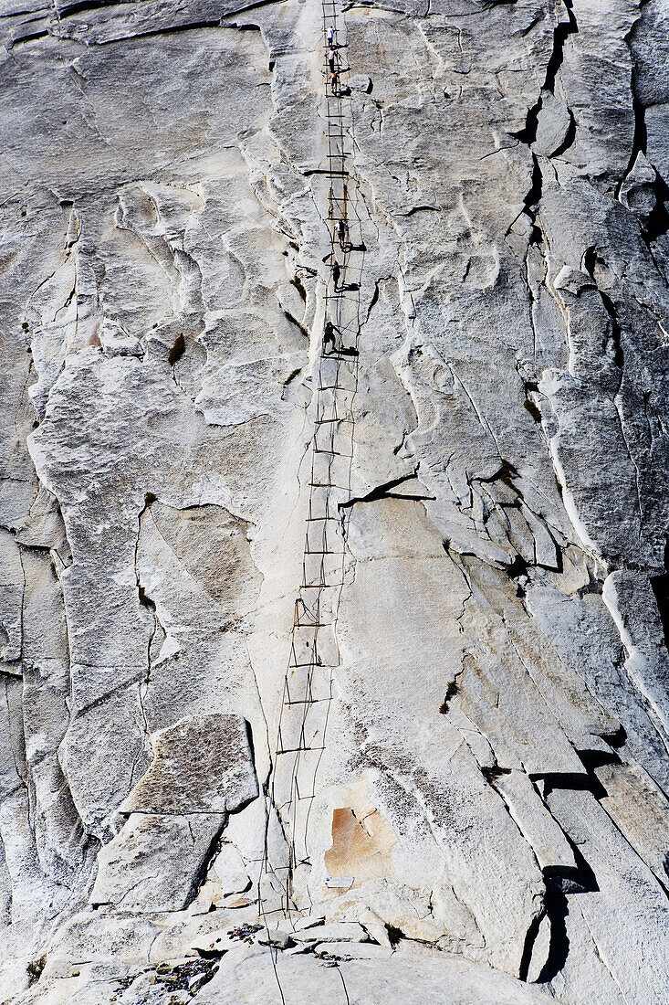 Hikers climbing the cables of Half Dome in Yosemite National Park, California.
