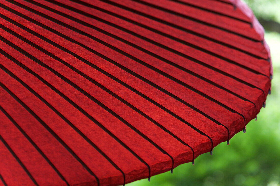Close-up, detail, of a decorative opened red paper umbrella.
