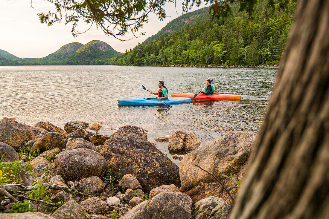 Side view of couple kayaking near shore of Jordan Pond in Acadia National Park, Maine, USA