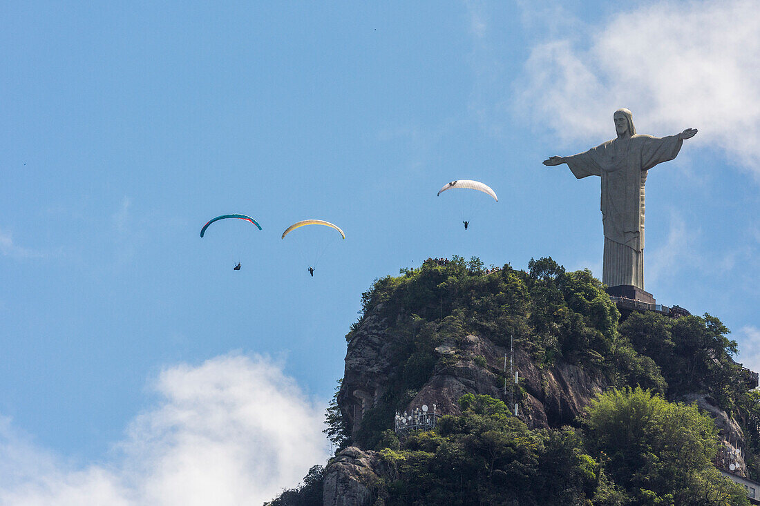 Paragliders flying over famous Christ the Redeemer statue on Corcovado mountain, Tijuca Forest National Park, Rio de Janeiro, Brazil