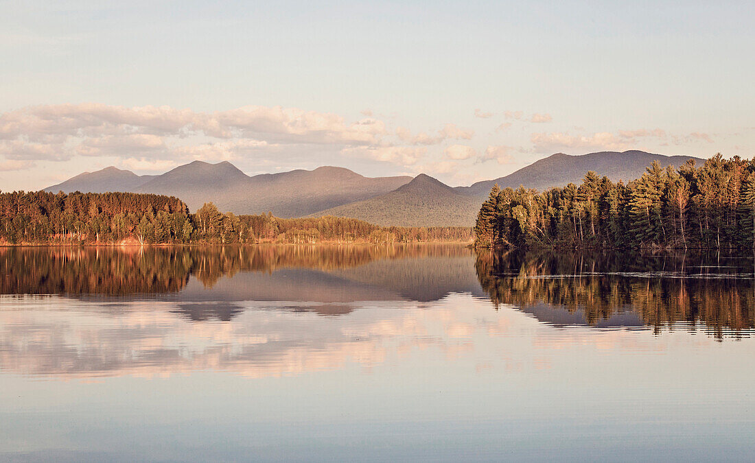 The late afternoon light catches the calm waters of Flagstaff Lake and Bigelow Mountain in the distance.
