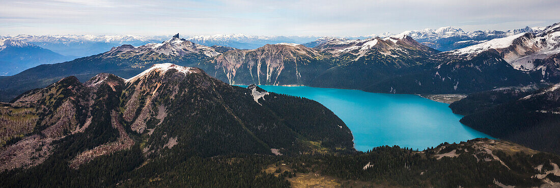 Garibaldi Lake in British Columbia, Canada. An turquoise colored alpine lake that is surrounded almost entirely by mountains. Iconic Black Tusk, the remains of a strato volcano can be seen in the background.