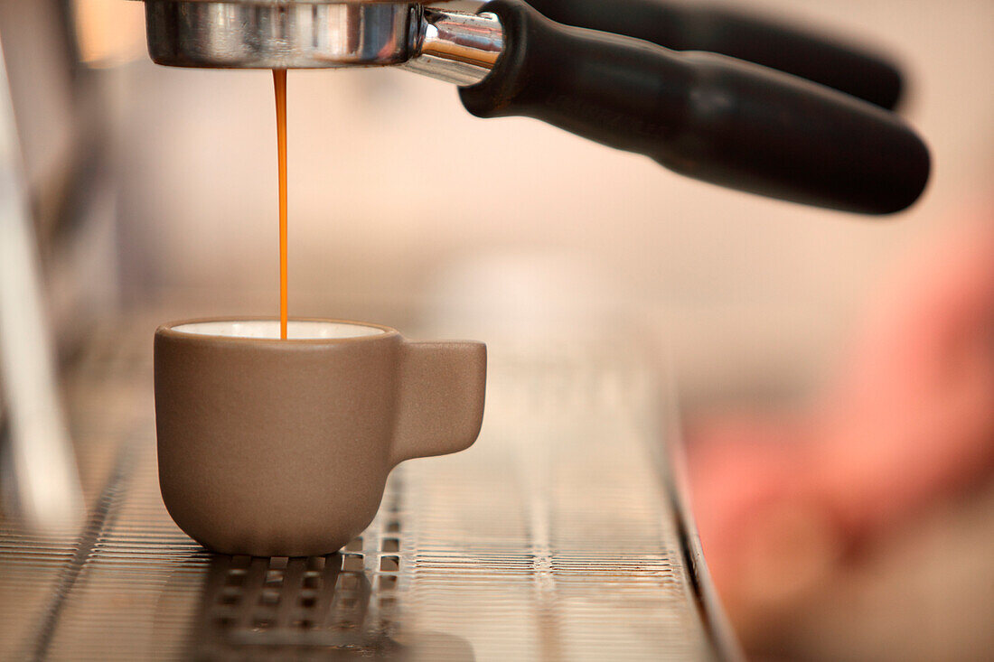 Espresso coffee pouring from coffee maker, Oakland, California, USA