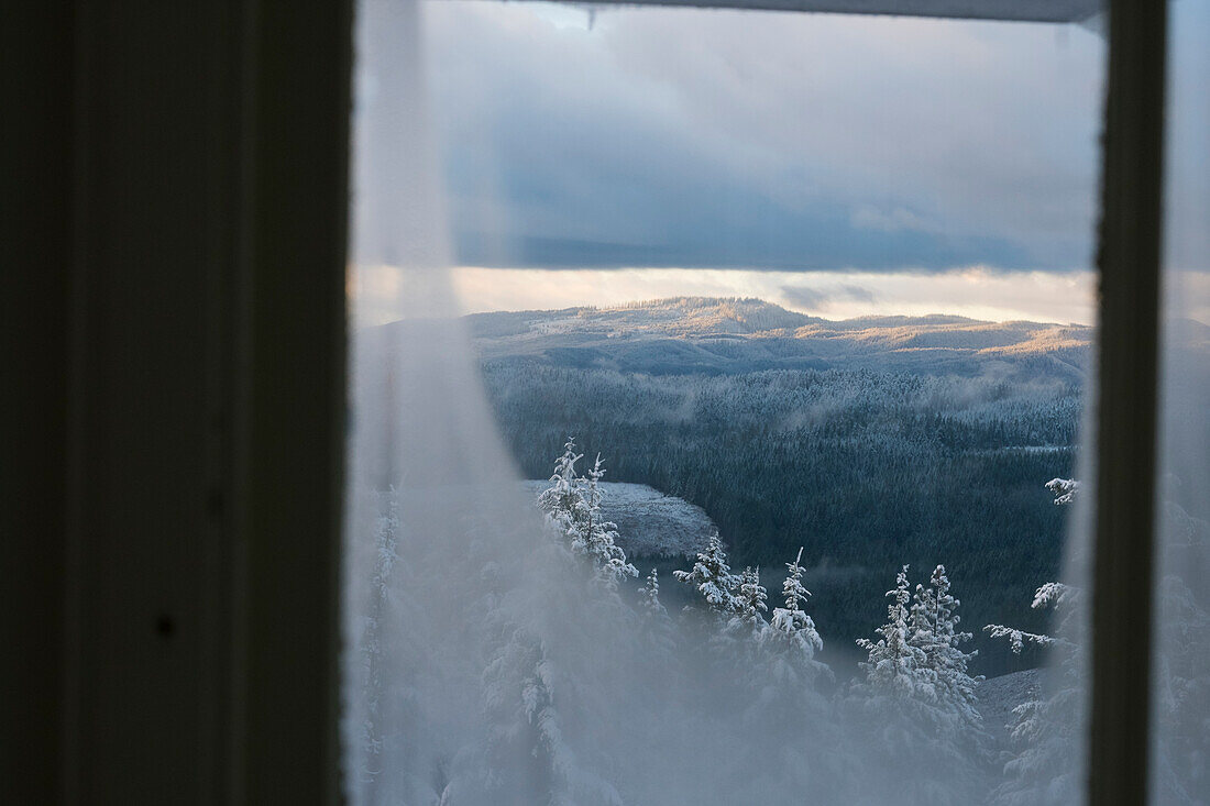 Snowy landscape view through window at Pickett Butte Fire Lookout near Tiller, Oregon, USA