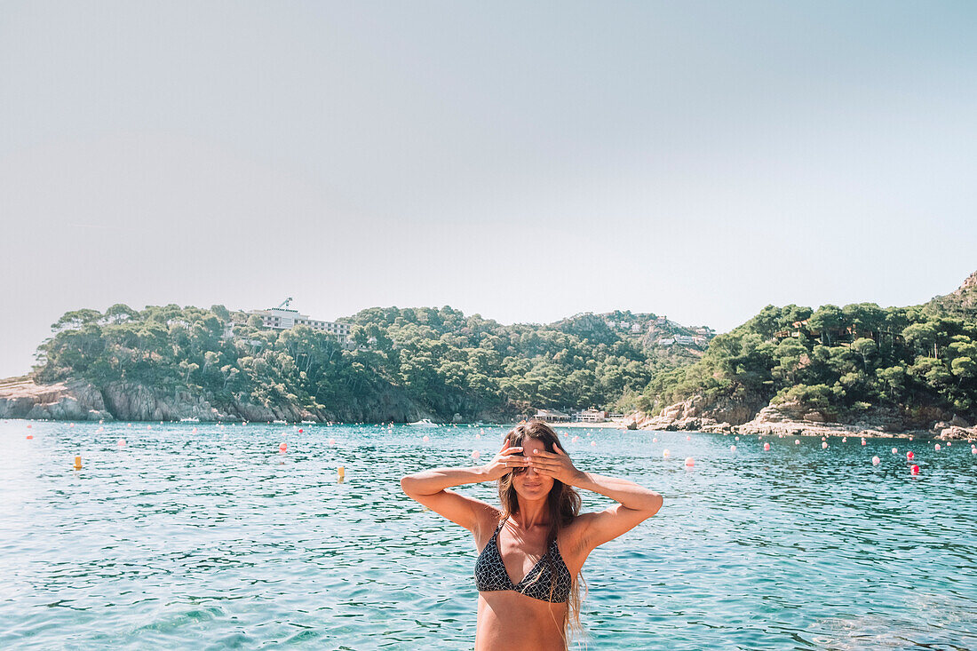 Woman in bikini standing in Mediterranean Sea, Costa Brava, Catalonia, Spain