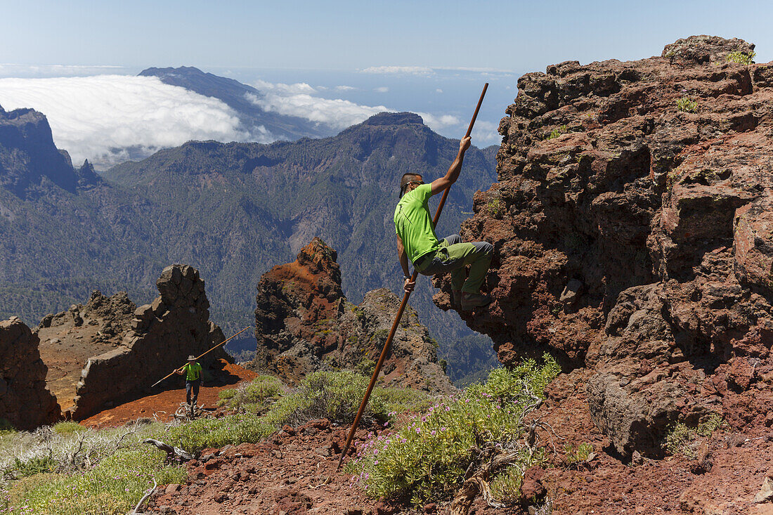 man climbing with the canarian crook, Salto del Pastor Canario, crater rim, Caldera de Taburiente, UNESCO Biosphere Reserve, La Palma, Canary Islands, Spain, Europe