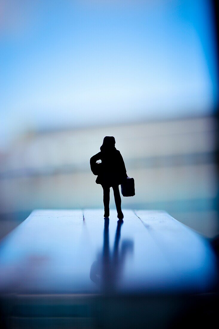 Silhouette of a woman with hand luggage and a package