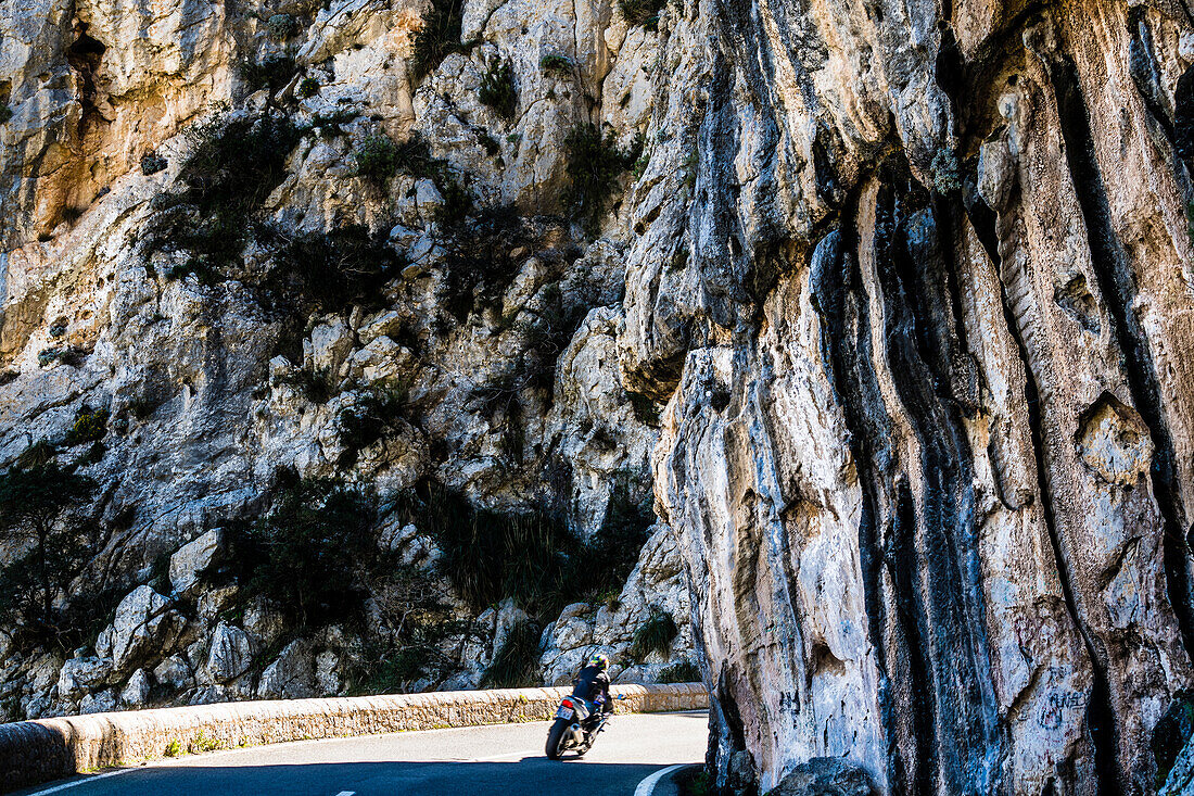 A motorcyclist on the famous winding road leading to Torrent de Pareis, Sa Calobra, Tramuntana Mountains, Mallorca, Spain