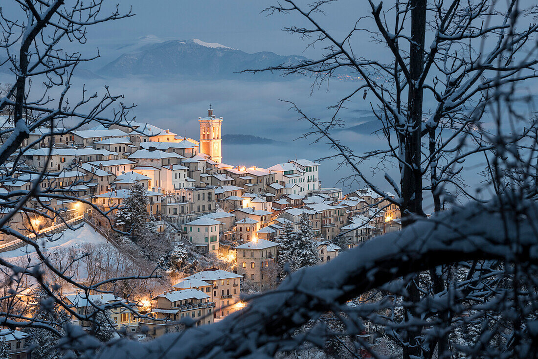 The Santa Maria del Monte framed by the braches after a snowfall in winter from Campo dei Fiori, Parco Campo dei Fiori, Varese, Lombardy, Italy, Europe