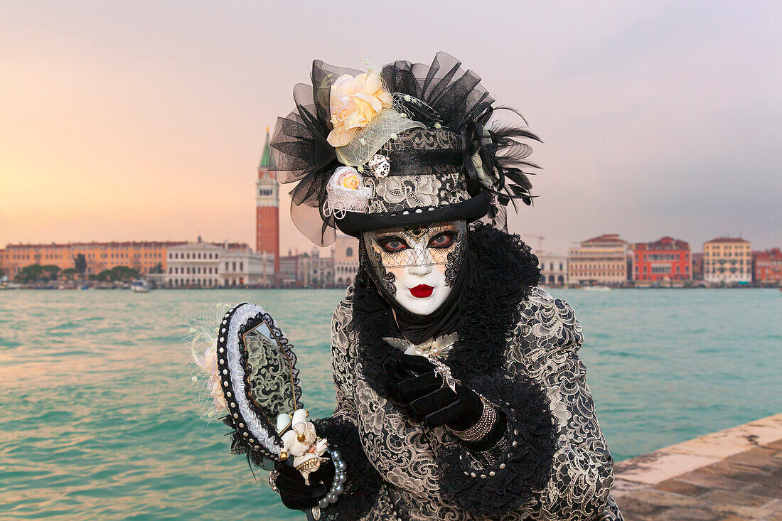 Typical mask of Carnival of Venice at San Giorgio island with San Marco Bell Tower on background, Venice, Veneto, Italy