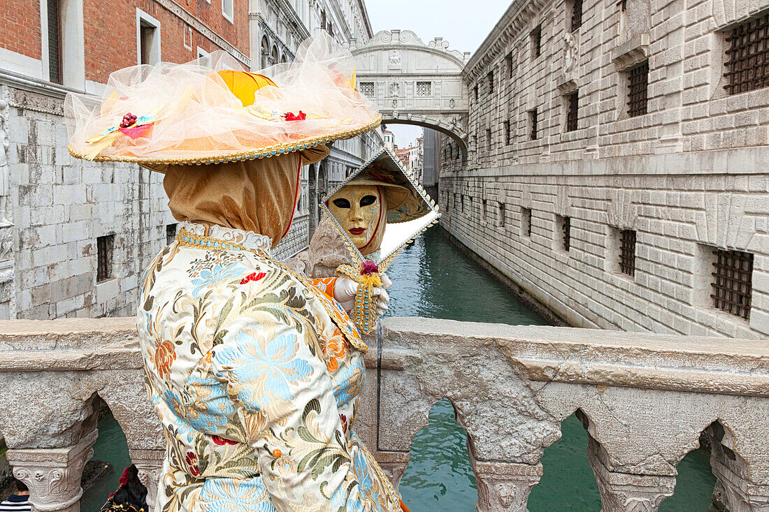 Typical mask of Carnival of Venice in front of Bridge of Sighs, Venice, Veneto, Italy