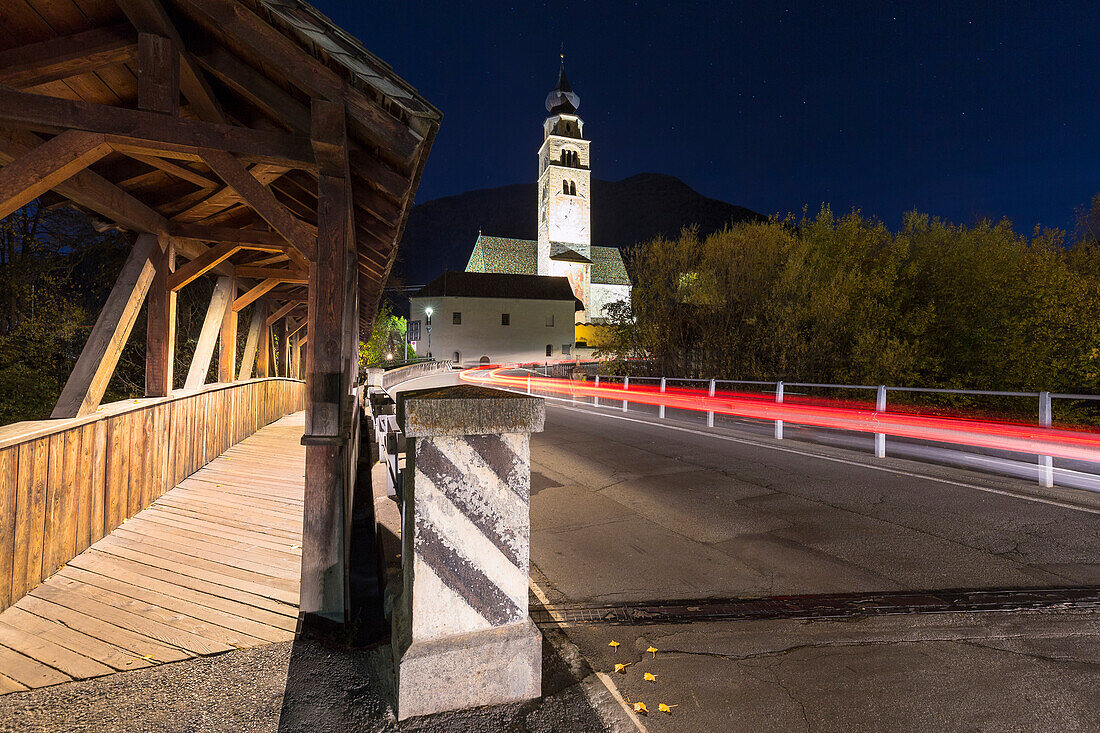 Car transit at night in front the church of Glorenza, Val Venosta, Sudtirol, Italy.