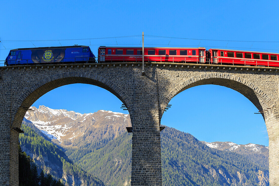 Red train transit on the Landwasser Viaduct, Filisur, Graübunden, Switzerland.