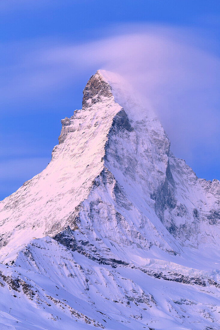 Matterhorn illuminated by the colors of dawn with the Hörnlihütte. Zermatt, Canton of Valais / Wallis, Switzerland.
