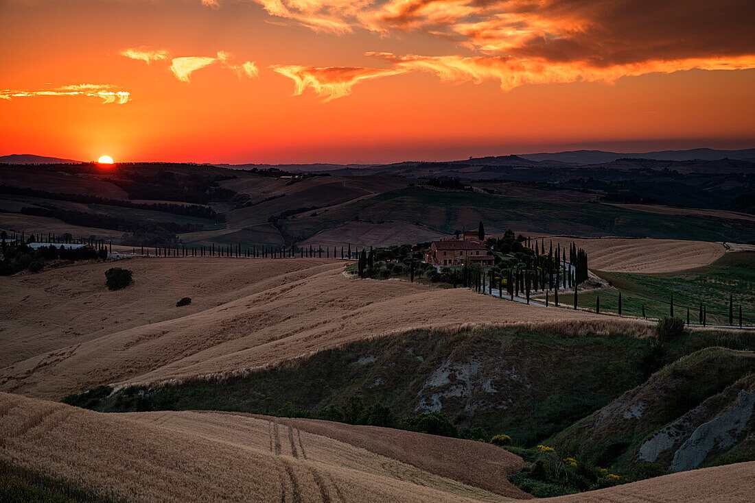 Red clouds at sunset over farm house in Tuscany, Asciano, Crete Senesi, Siena province, Tuscany, Italy
