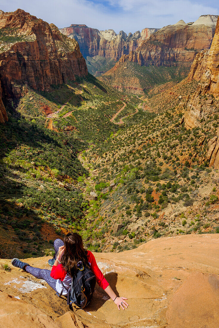 Photograph with female hiker looking at view of Zion Canyon in Zion National Park, Utah, USA