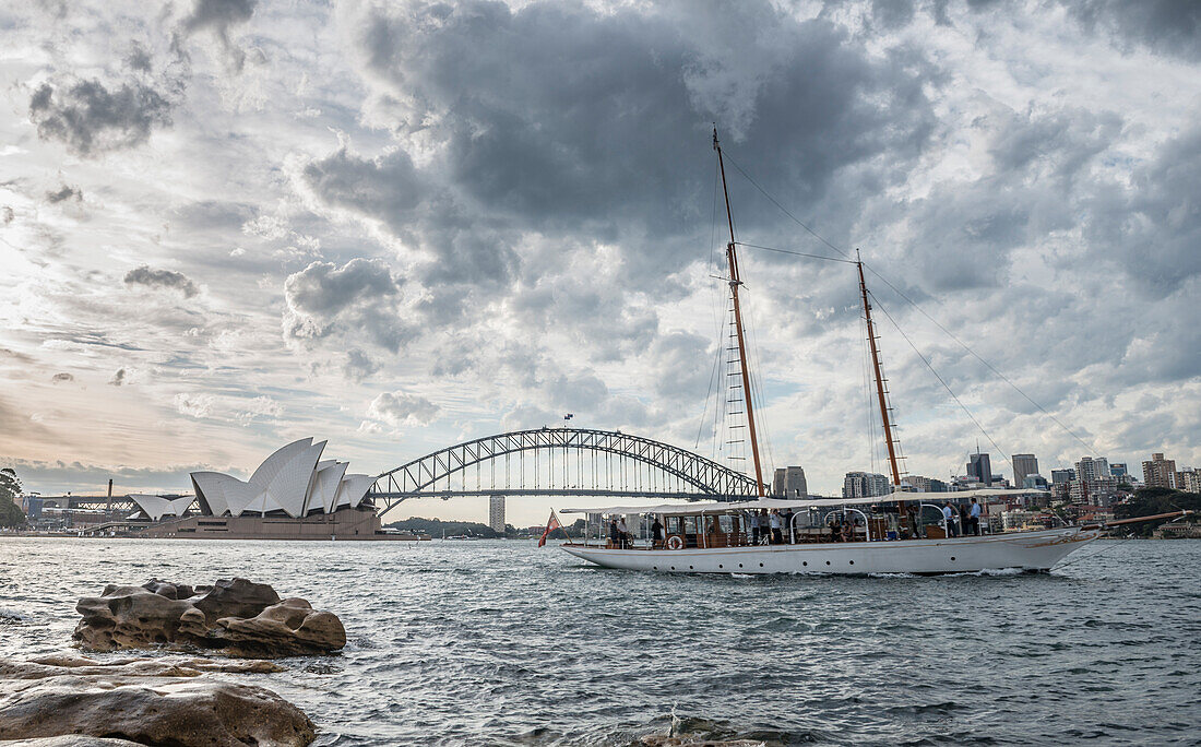 Large white clouds over tourboat sailing in front of Sydney Harbor, Sydney, New South Wales, Australia