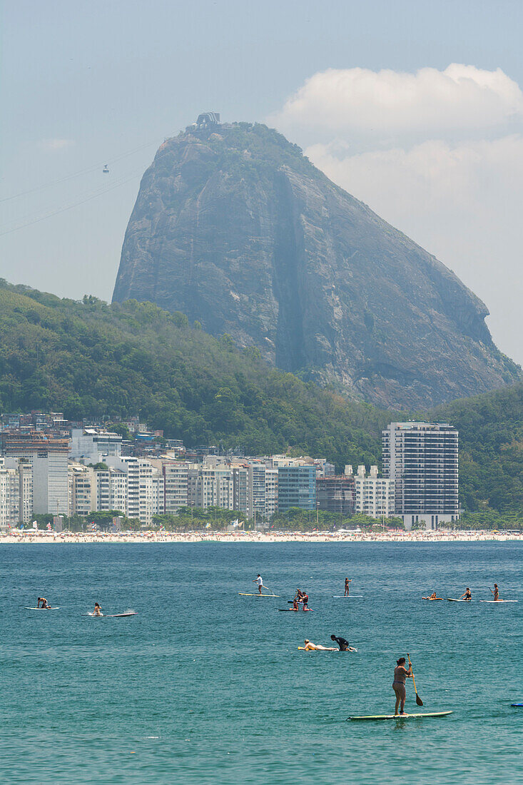 People enjoying a sunny day on a Stand Up Paddle board in Praia de Copacabana, Rio de Janeiro, Brazil