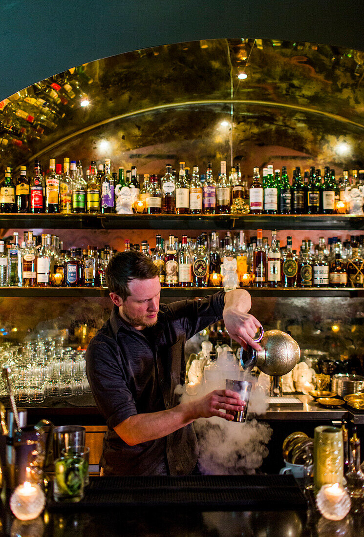 A bartender makes a fancy cocktail at a swanky bar in Seattle's Capital Hill neighborhood.