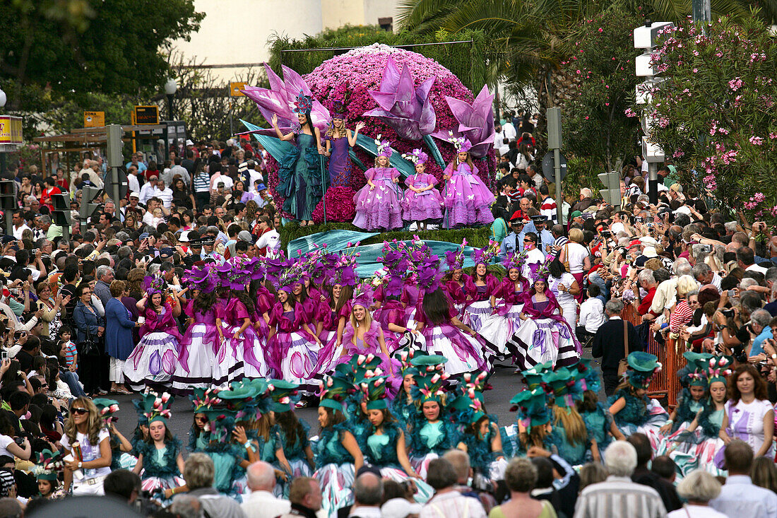 Festival girls in flower costumes posing on a Floral float at the Madeira Flower Festival Parade, Funchal, Madeira, Portugal