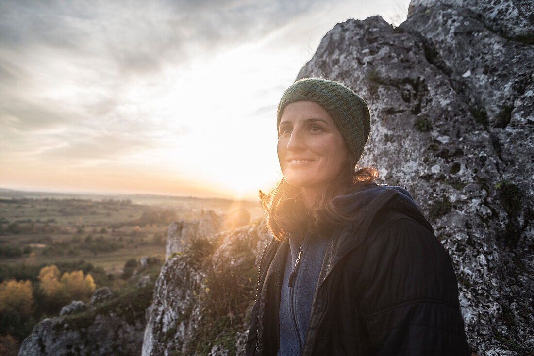 Portrait of young woman in knit hat against rock formation, Polish Jura, Rzedkowice, Silesia, Poland