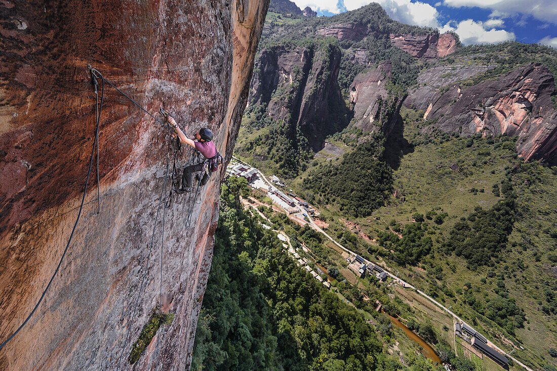Side view of adventurous rock climber climbing challenging cliff, Liming, Yunnan Province, China