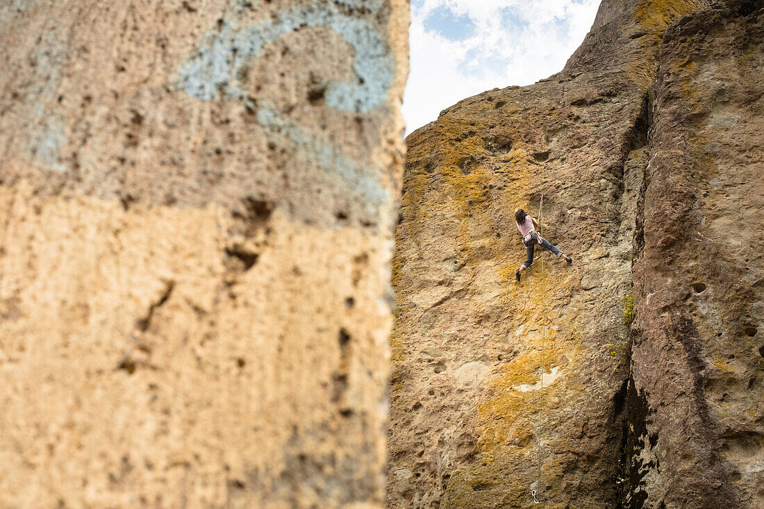 View of adventurous rock climber climbing challenging cliff, Mexico