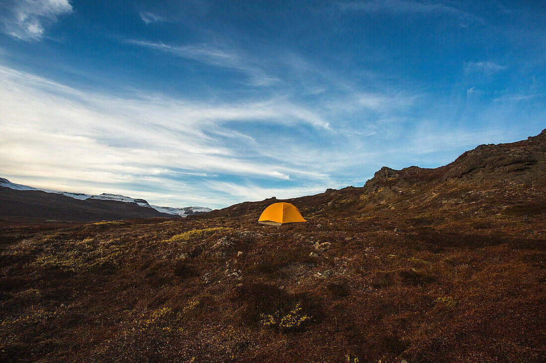 Greenland offers some of the most spectacular landscape to explore and camp within here, a lone tent is set up in the autumn-clad hills of Disko Island