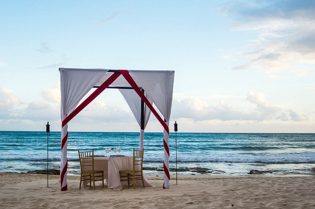 Fancy dinner table with awning on beach for romantic dinner by ocean, Puerto Morelos, Yucatan Peninsula, Mexico
