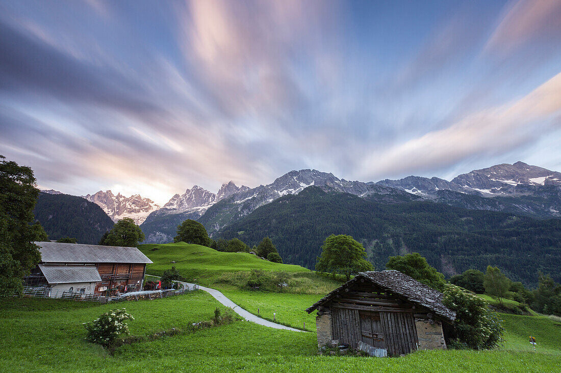 Sunrise above green meadows of Soglio, Bregaglia Valley, Maloja Region, Canton of Graubunden, Switzerland