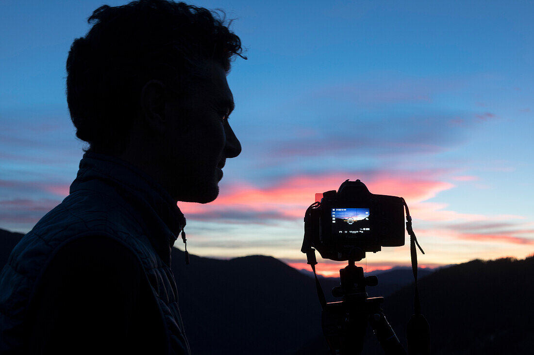 Silhouette of photographer and camera on tripod, Dolomites, South Tyrol, Italy