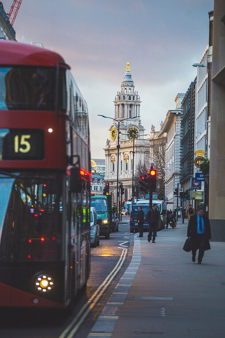 A detail of St Paul Cathedral with an iconic red bus on the foreground. London, United Kingdom.
