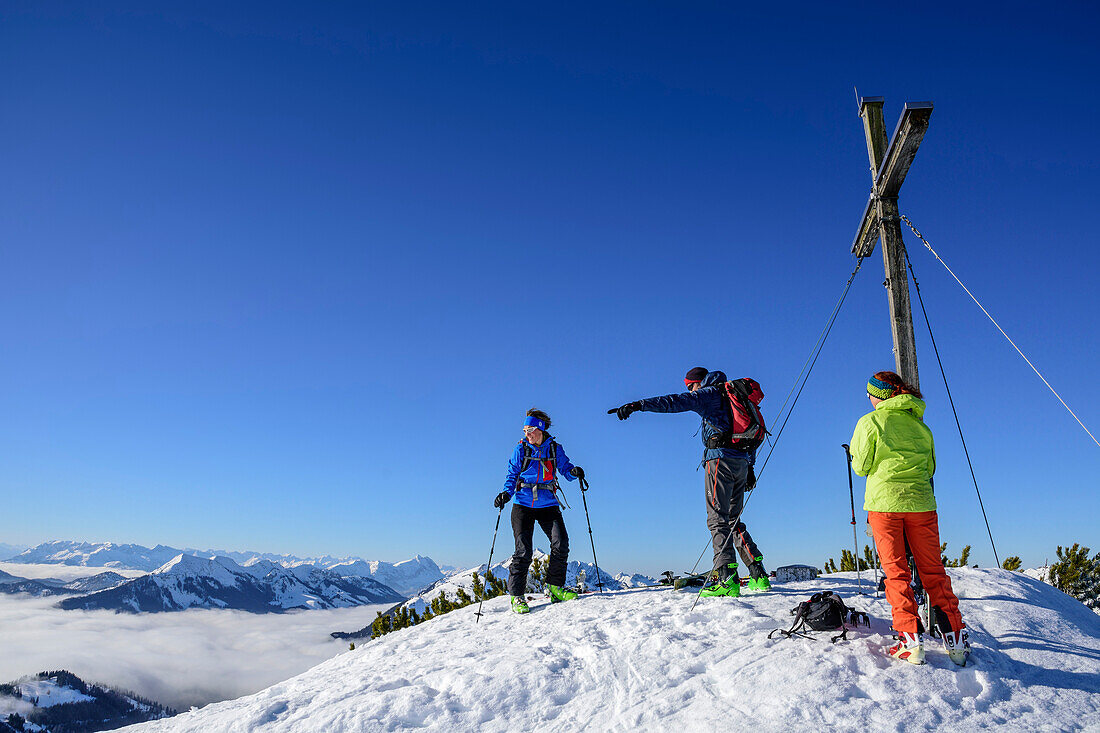Three persons backcountry skiing standing at the summit of Trainsjoch, Trainsjoch, Bavarian Alps, Upper Bavaria, Bavaria, Germany