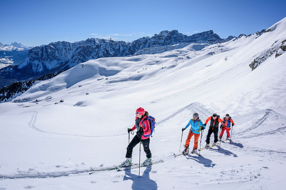 Several persons backcountry skiing ascending to Peitlerkofel, Geisler range in background, Peitlerkofel, Natural Park Puez-Geisler, UNESCO world heritage site Dolomites, Dolomites, South Tyrol, Italy