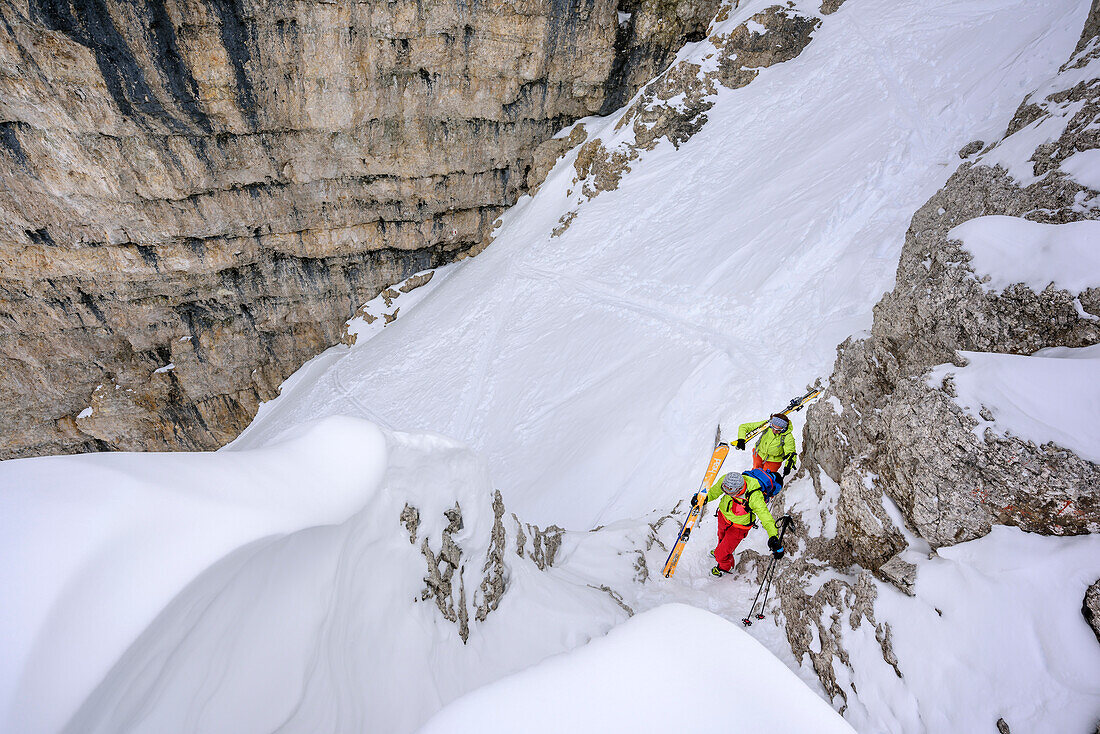 Zwei Personen auf Skitour steigen durch Felsrinne zur Puezspitze auf, Puezspitze, Naturpark Puez-Geisler, UNESCO Weltnaturerbe Dolomiten, Dolomiten, Südtirol, Italien