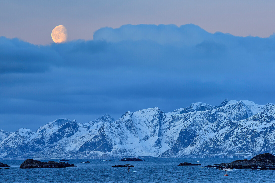 Mond über verschneiten Bergen und Küste, Lofoten, Nordland, Norwegen