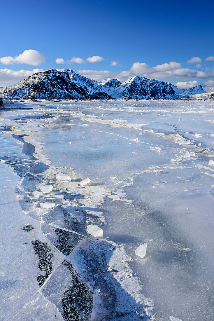 Vereister Strand mit verschneiten Bergen, Lofoten, Nordland, Norwegen